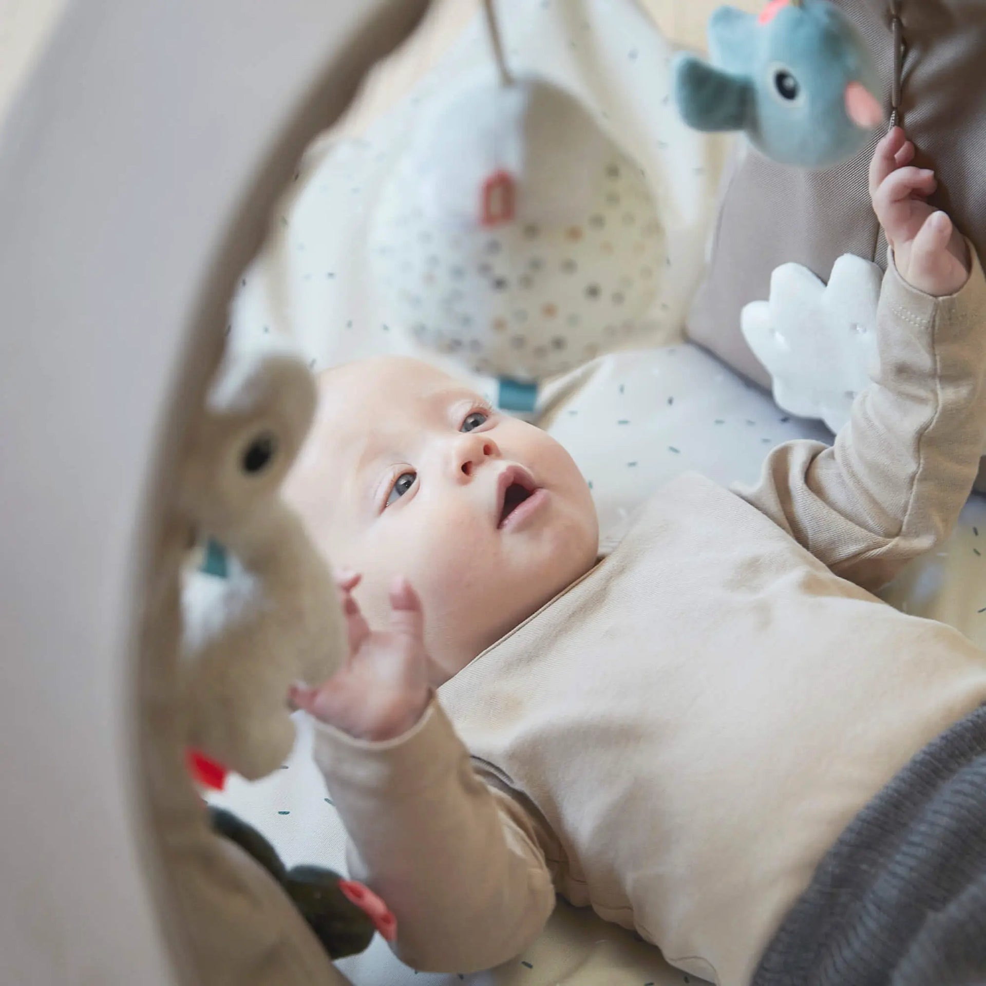 Baby unter Spielbogen mit hängendem Spielzeug – Baby Spieldecke zur Förderung von Motorik, Greifen und Sinnesentwicklung