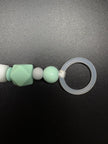 Nahaufnahme des Silikonrings der personalisierten Schnullerkette Dino mit Namen von BabyLions® mit mintfarbener Silikonperle, Holzperle und hochwertigem Schnulleradapter