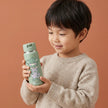 Kind hält TINY Thermo Kinder Trinkflasche Koala 200 ml aus Edelstahl in Salbeigrün – BPA-freie, auslaufsichere Isolierflasche mit Strohhalm für Kindergarten, Ausflüge und unterwegs
