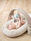 Baby liegt unter Activity Gym Lalee von Done by Deer und greift nach Spielzeug