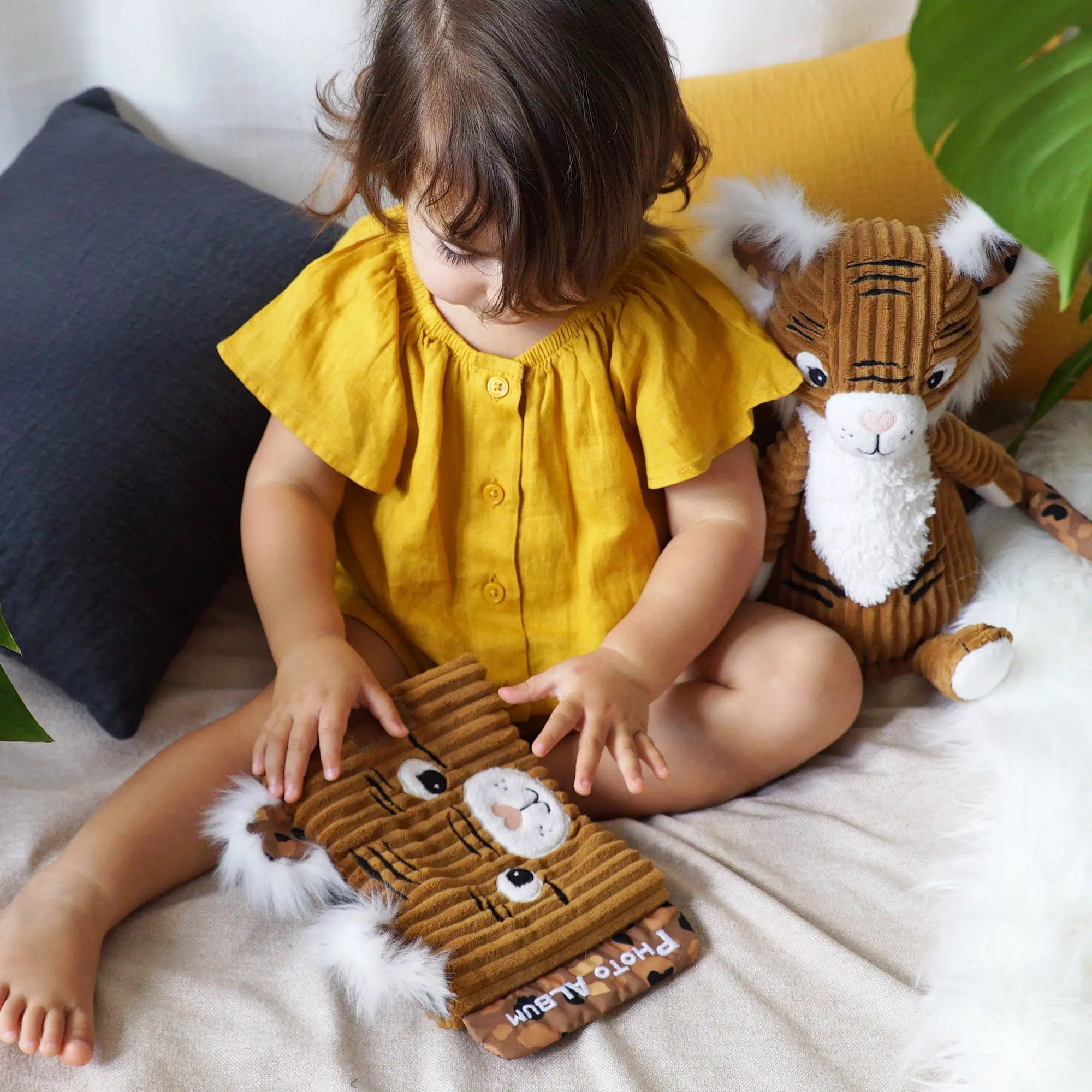 Baby spielt mit Fotoalbum Tiger aus Plüsch – weiches Stoffalbum für Babyfotos im Alltag