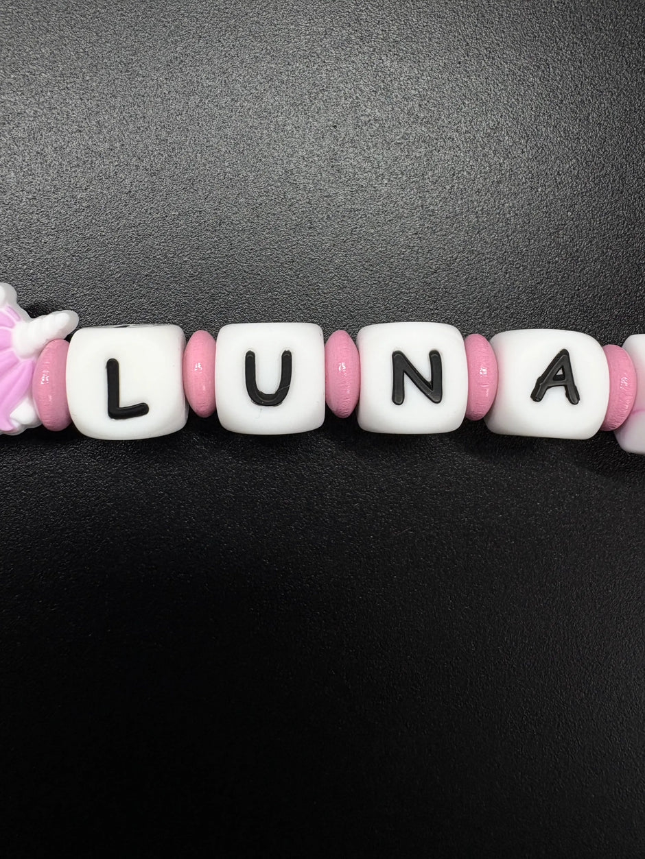Detailaufnahme der personalisierten Schnullerkette mit dem Namen Luna in Rosa und Weiß