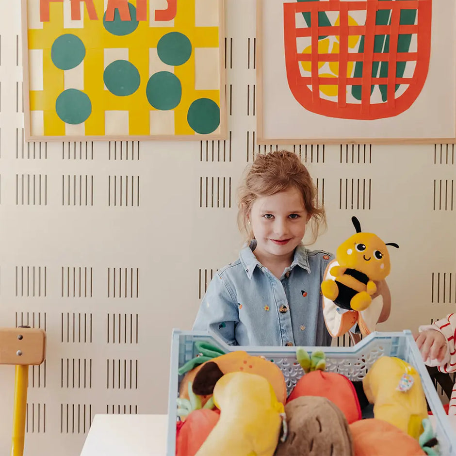 Kind spielt mit gelbem 2-in-1 Biene Plüschtier im Kinderzimmer