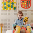 Kind spielt mit gelbem 2-in-1 Biene Plüschtier im Kinderzimmer