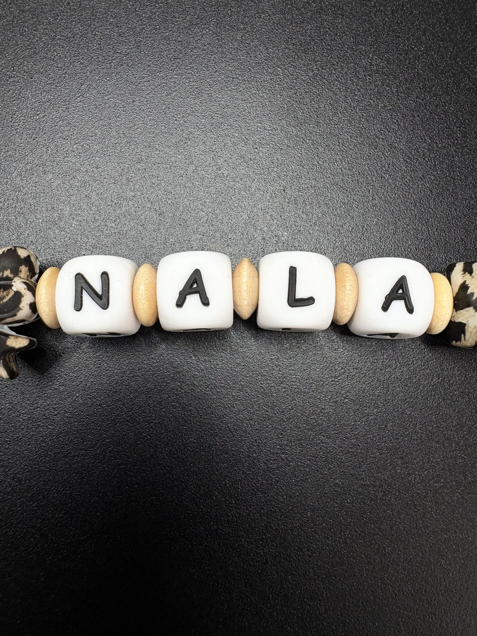 Namensperlen Nala auf personalisierter Schnullerkette mit Leopardenmuster und Holzringen