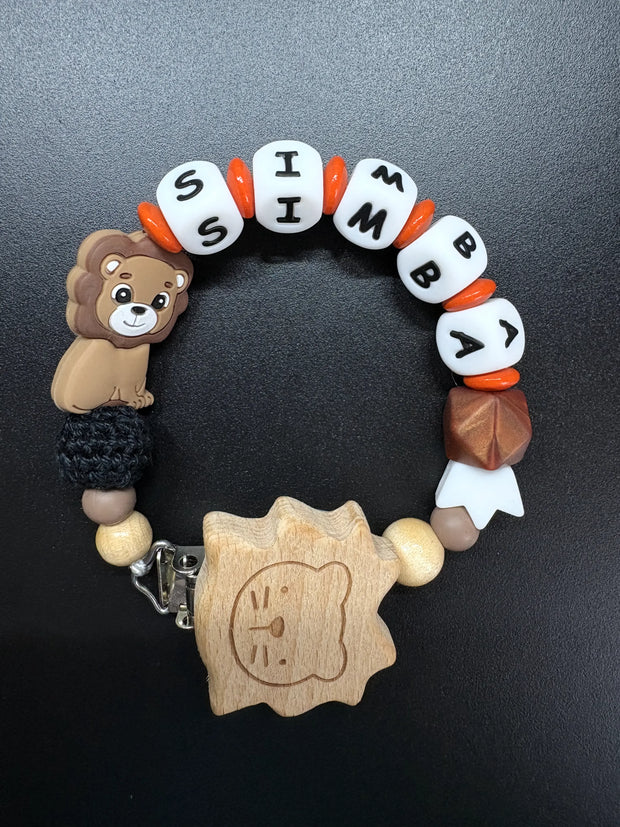 Personalisierte Schnullerkette Simba mit Löwenmotiv, Holzclip, weißen Namensperlen und orangefarbenen Akzenten
